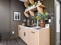Charming coffee nook with modern decor, open shelving, and sleek tiled backsplash!