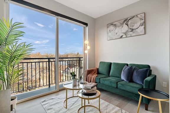 right, stylish living space with lush green sofa, modern art, and balcony views.