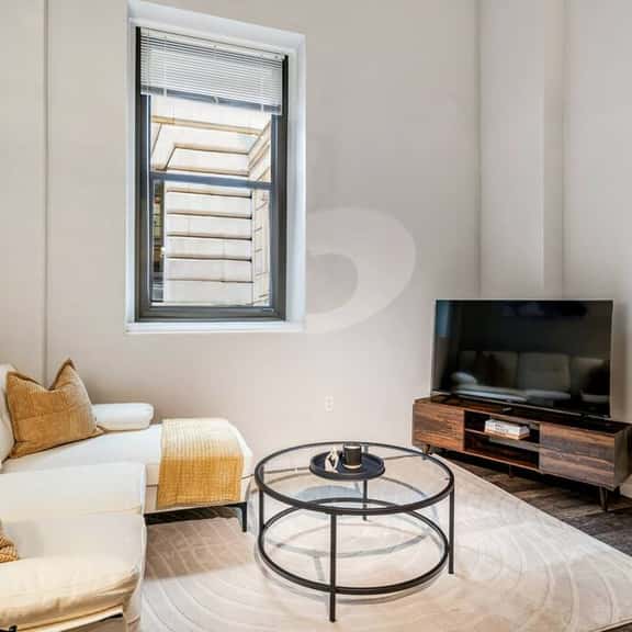 Bright living space with cozy seating, smart TV, and a sleek, modern design.