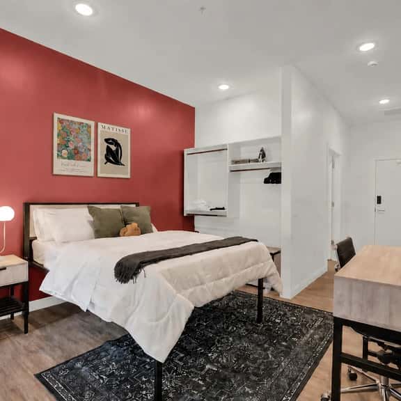 Modern bedroom with bold accent wall, workspace, and cozy designer touches